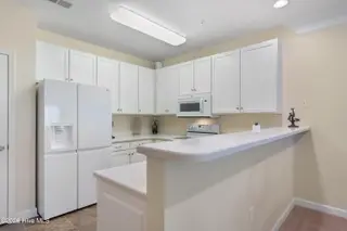 221 Woodlands Way Unit 21, Calabash, NC 28467 — 2-bedroom condo in Crow Creek, Calabash, NC, photo 11 of 39: Kitchen with Corian Counters