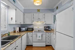 1000 Caswell Beach Road Apt. 806, Oak Island, NC 28465 — 2-bedroom condo in Oak Island Bch Villa, Oak Island, NC, photo 12 of 56: Kitchen - White Appliances