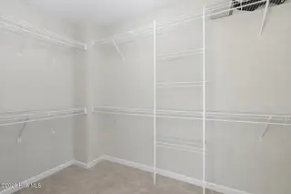 404 Hidden Oaks Drive, Jacksonville, NC 28546 – photo 21: Decluttered walk-in closet with white sh
