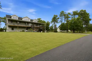 354 W South Shore Drive, Southport, NC 28461 — 3-bedroom home in Boiling Spring Lakes, Southport, NC, photo 2 of 39: 14 photo left side view green grass
