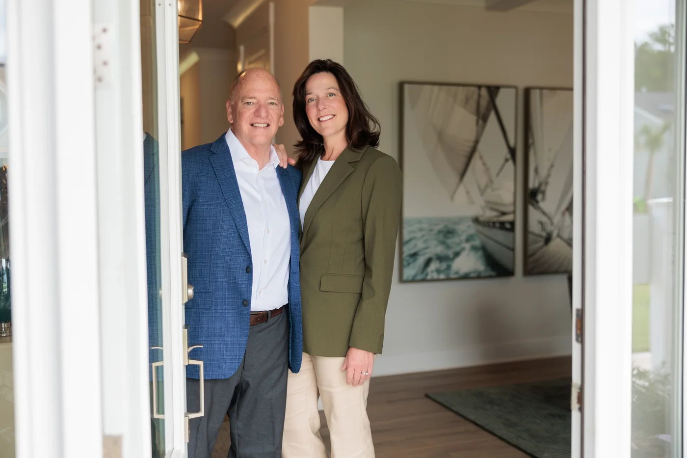 Buddy Blake stands with a woman in the open doorway of a home.